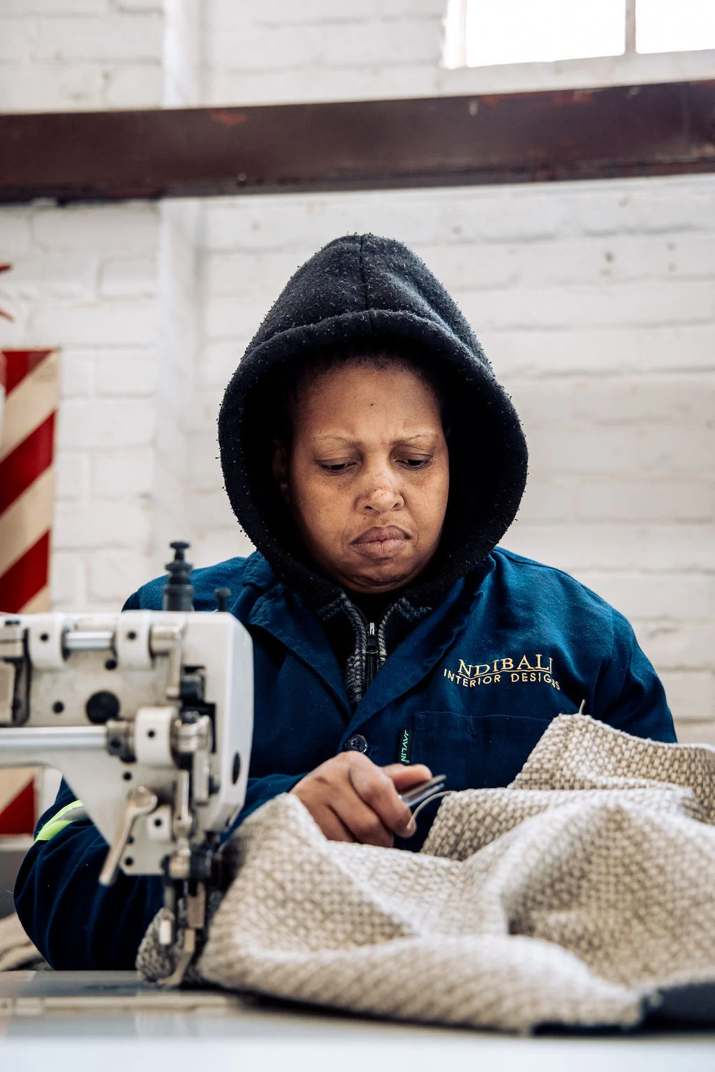Ndibali team member sewing upholstery